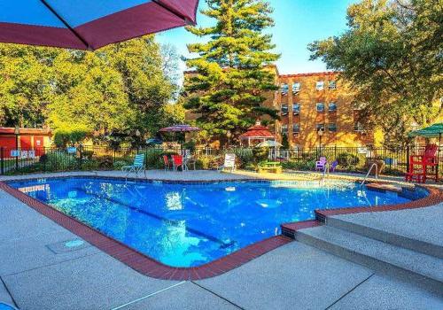 Outdoor pool with lounge chairs and umbrellas at Bromley House apartments for rent